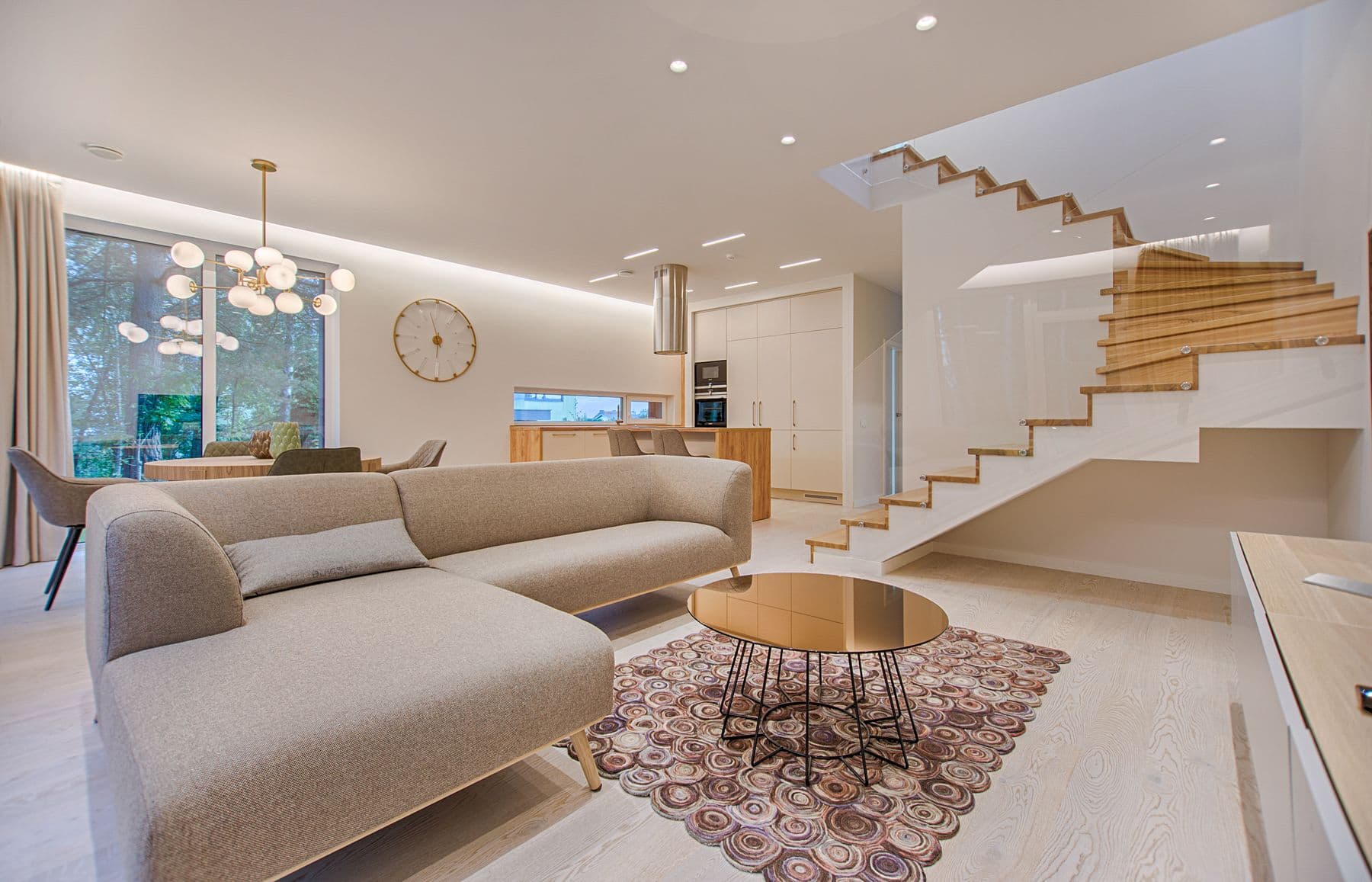 Salon contemporain lumineux, canapé clair et grande fenêtre sur le jardin